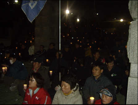 14일 저녁 울산과학대학 정문 앞에서 촛불시위를 하고 있는 노동자들. 